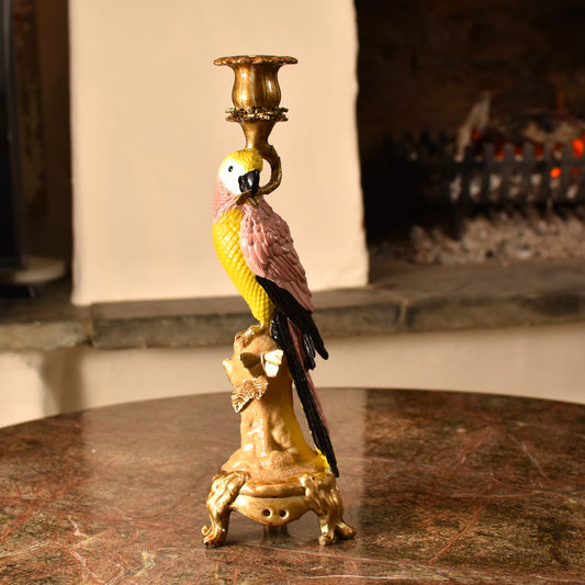Candle holder shaped like a pink & yellow parrot with a gold base