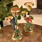Decorative candle holders with toucan designs on a marble surface.