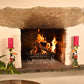 Fireplace with burning logs, flanked by decorative toucan candle holders with pink candles.